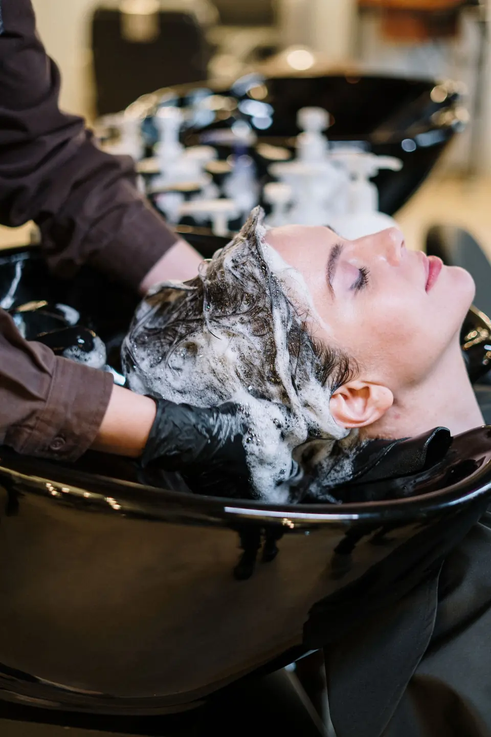 Klant krijgt een hoofdmassage bij de wasbak